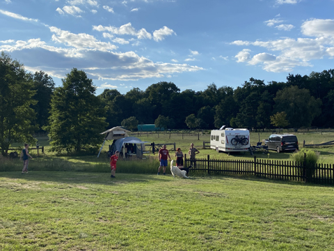 Campingwiese mit Zelten und Wohnmobil